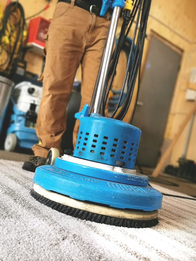 Close up of Chris O'Brien using a Rotostatic carpet cleaning scrubber in the shop
